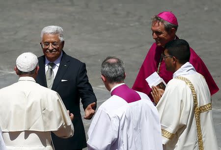 Pope Francis (L) embraces Palestinian President Mahmoud Abbas (2nd L) at the end of the ceremony for the canonisation of four nuns at Saint Peter's square in the Vatican City, May 17, 2015. REUTERS/Tony Gentile