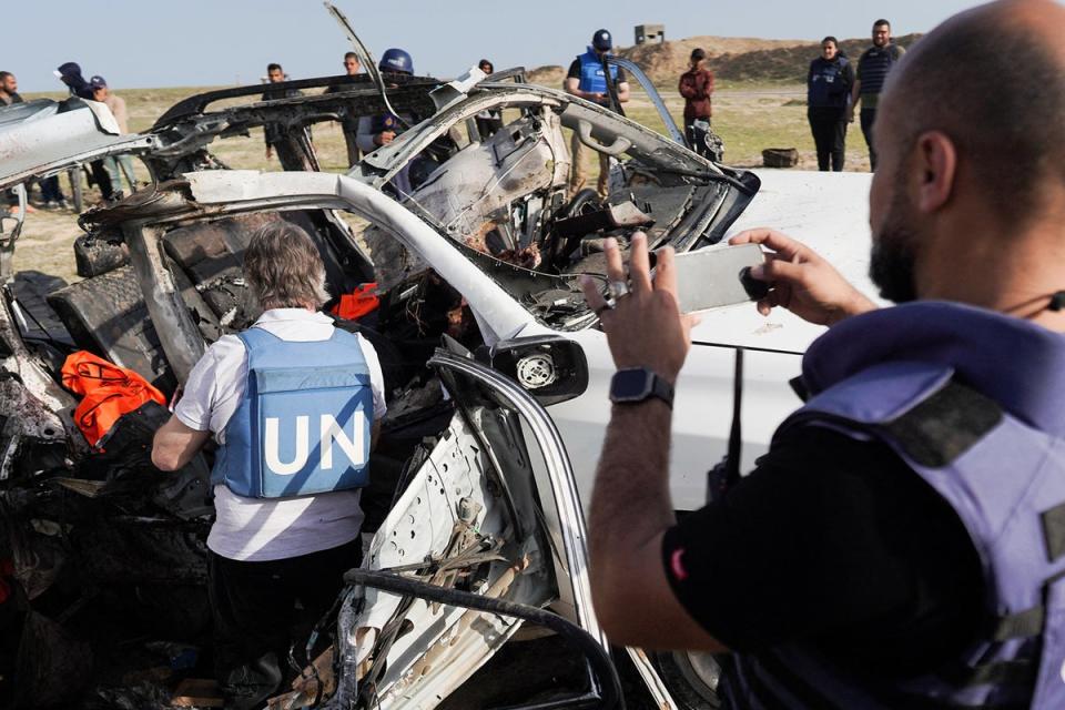United Nations staff members inspect the wreckage of a car used by WCK (AFP/Getty)