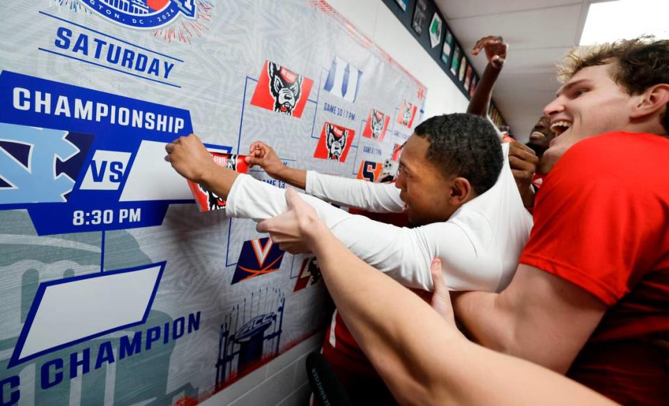 N.C. State’s KJ Keatts is lifted to put the Wolfpack sticker on the wall after N.C. State’s 72-65 overtime victory over Virginia in the semifinals of the 2024 ACC Men’s Basketball Tournament at Capital One Arena in Washington, D.C., Friday, March 15, 2024.