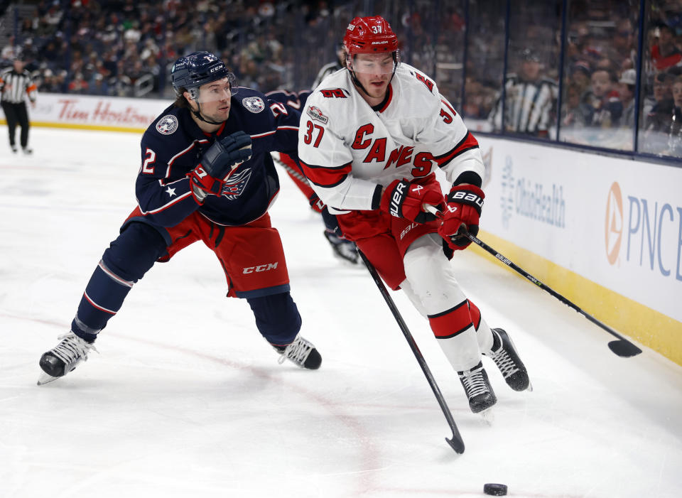 Carolina Hurricanes forward Andrei Svechnikov, right, chases the puck in front of Columbus Blue Jackets defenseman Andrew Peeke during the first period of an NHL hockey game in Columbus, Ohio, Saturday, Jan. 7, 2023. (AP Photo/Paul Vernon)