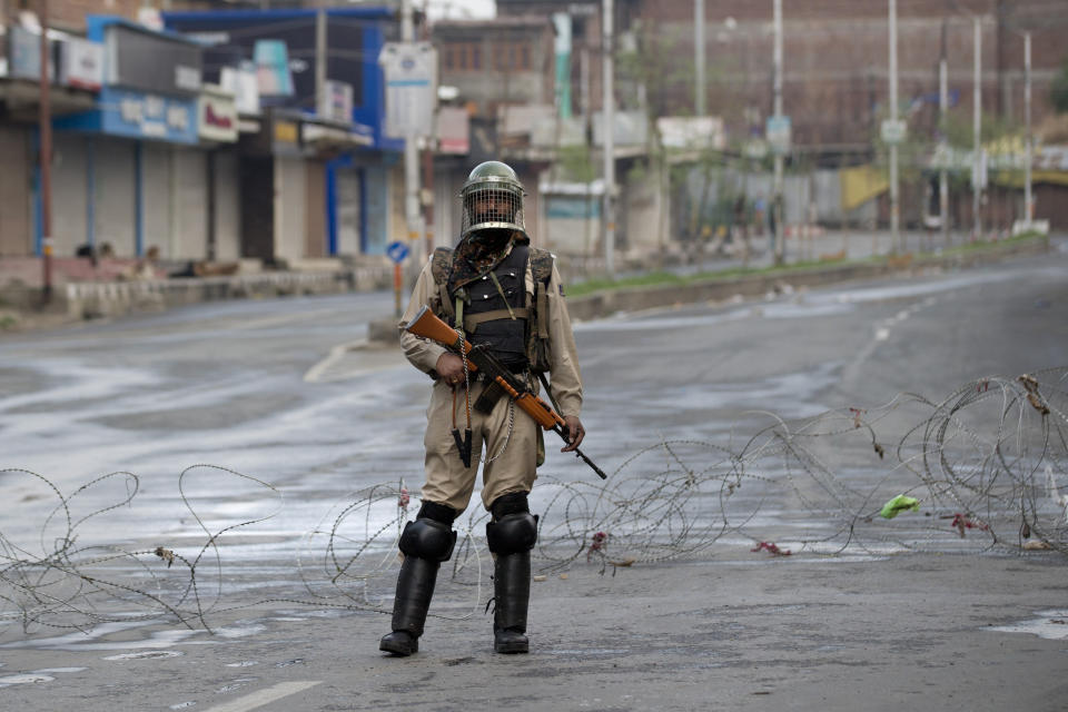 An Indian Paramilitary soldier stands guard on a deserted road during curfew in Srinagar, Indian controlled Kashmir, Wednesday, Aug. 7, 2019. Authorities in Hindu-majority India clamped a complete shutdown on Kashmir as they scrapped the Muslim-majority state's special status, including exclusive hereditary rights and a separate constitution, and divided it into two territories. (AP Photo/Dar Yasin)