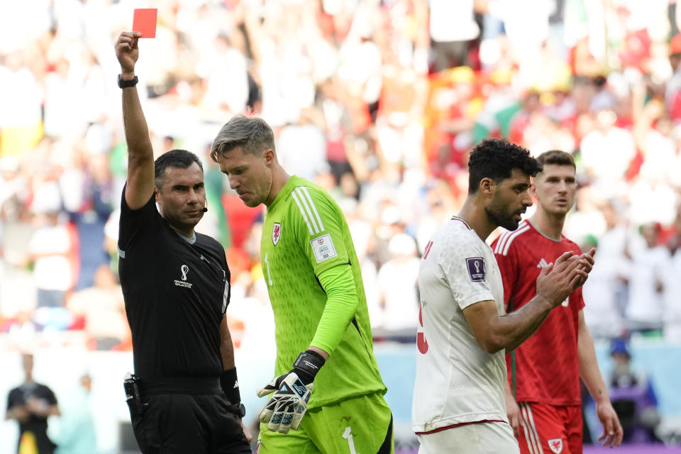 El árbitro Mario Alberto Escobar (izquierda) muestra una tarjeta roja al portero de Gales, Wayne Hennessey, durante un partido del Grupo B del Mundial contra Irán, en el estadio Ahmad Bin Ali en Rayán, Qatar, el 25 de noviembre de 2022. (AP Foto/Francisco Seco)