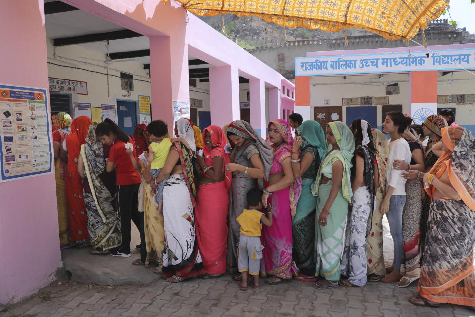 Indian women stand in a queue to cast their votes at a polling station in a village in Neemrana, in the Indian state of Rajasthan, Monday, May 6, 2019. Polls opened Monday for the crucial fifth phase of India's marathon elections including in two constituencies in the vote-rich state of Uttar Pradesh, where opposition Congress party president Rahul Gandhi and his mother Sonia Gandhi hope to retain their seats. (AP Photo/Manish Swarup)