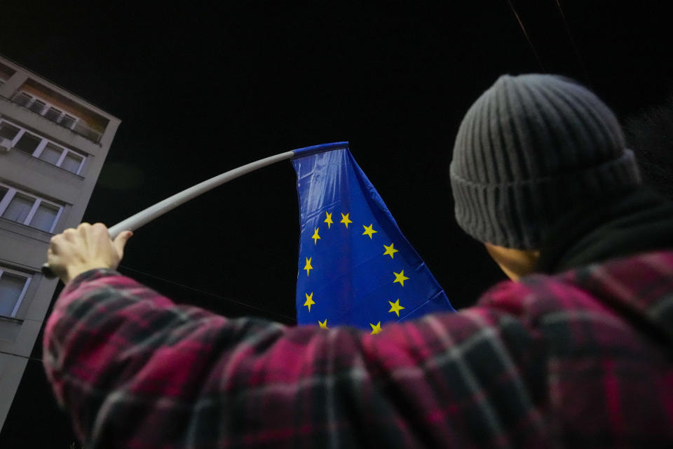 A protester waves an EU flag during a rally in downtown Belgrade, Serbia, Tuesday, Jan. 16, 2024. People rallied accusing the populist authorities of President Aleksandar Vucic of orchestrating a fraud during the Dec. 17 parliamentary and local election. The ruling Serbian Progressive Party was declared the election winner but the main opposition alliance, Serbia Against Violence, has claimed the election was stolen, particularly in the vote for the Belgrade city authorities. (AP Photo/Darko Vojinovic)