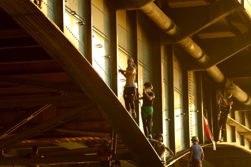 Iraqi demonstrators climb Al Jumhuriya bridge during the ongoing anti-government protests in Baghdad