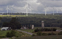 FILE - In this Aug. 4, 2008, file photo, wind turbines from the Maple Ridge Wind Farm, the state's largest wind farm, loom above the horizon in Martinsburg, N.Y. A new law signed Thursday, July 18, 2019, by New York Gov. Andrew Cuomo sets the nation's most aggressive targets for reducing carbon emissions and is intended to drive dramatic changes over the next 30 years. It calls for all the state's electricity to come from renewable, carbon-free sources such as solar, wind and hydropower. Transportation and building heating systems would also run on clean electricity rather than oil and gas. (AP Photo/Mike Groll, File)