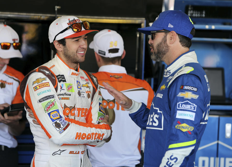 Chase Elliott, left, and Jimmie Johnson talk inside the garage area before practice for the NASCAR Cup Series auto race at Phoenix International Raceway, Friday, Nov. 10, 2017, in Avondale, Ariz. Both drivers are looking to fill the final spot for the Championship 4. (AP Photo/Ralph Freso)