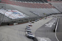 Drivers make their way around the track past empty stands during a NASCAR Xfinity Series auto race at Bristol Motor Speedway Monday, June 1, 2020, in Bristol, Tenn. The race is being run without fans in the stands due to the coronavirus outbreak. (AP Photo/Mark Humphrey)