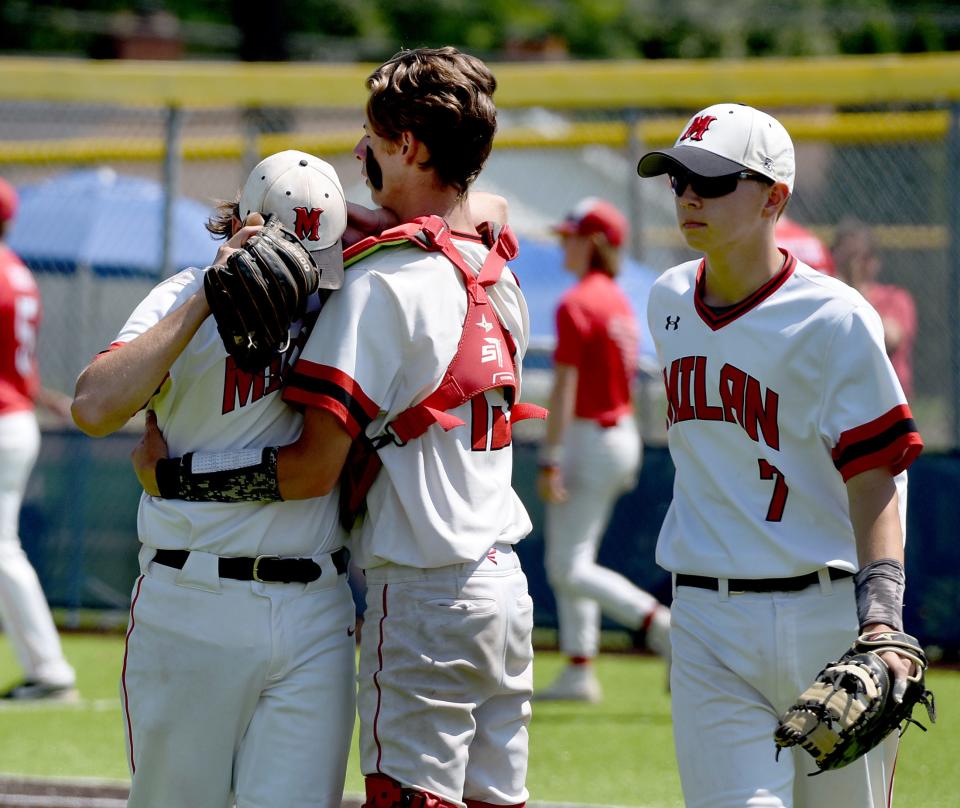 Milan pitcher Evan Morelock is greeted by catcher Cody Wikaryasz and Matthew Bowman after a tough loss to Grosse Ile in the finals of the Division 2 Regional at Livonia Franklin Saturday.