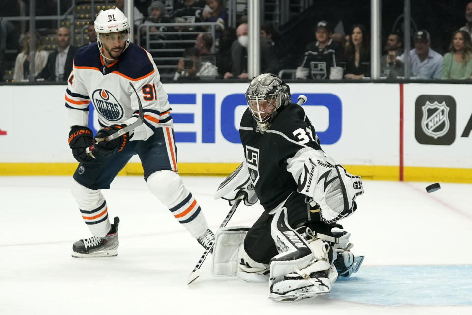 Los Angeles Kings goaltender Jonathan Quick, right, deflects a shot as Edmonton Oilers left wing Evander Kane watches during the first period in Game 3 of an NHL hockey Stanley Cup first-round playoff series Friday, May 6, 2022, in Los Angeles. (AP Photo/Mark J. Terrill)