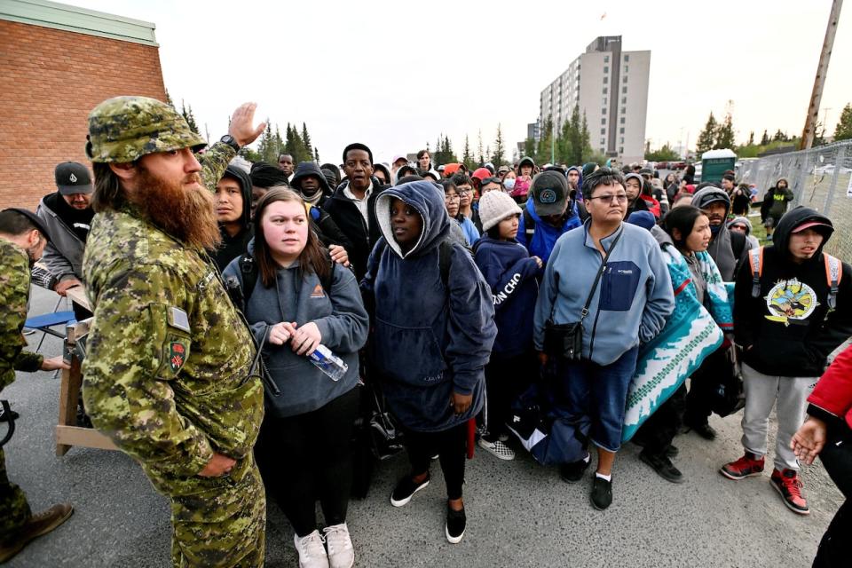 Residents of Yellowknife wait to register for evacuation on Aug. 18 as wildfires threaten the Northwest Territories capital. (Jennifer Gauthier/Reuters - image credit)