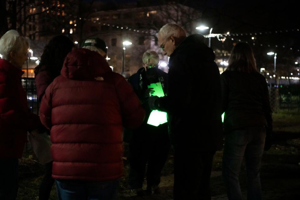 Members of the Calhoun County Spartans collect luminaries commemorating the anniversary of the Michigan State University mass shooting during a vigil at Clara's in Battle Creek on Tuesday, Feb. 13, 2024.