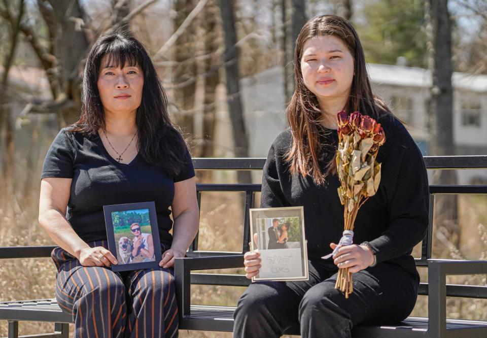 Laura Okulski, left, and her daughter, Amanda Okulski, display photos of Amanda's boyfriend Jakob Mumper as they sit on a bench at Switchyard Park in Bloomington. The bench is a memorial dedicated to Jakob, his mother, and sister, who were killed Sept. 6, 2020.
