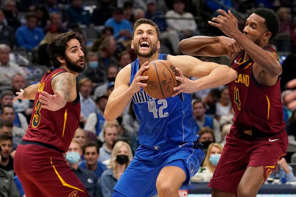 Cavaliers guard Ricky Rubio (3) and center Evan Mobley (4) defend against a drive to the basket by Dallas Mavericks' Maxi Kleber (42) in the first half of the Cavs' 114-96 win Monday in Dallas. [Tony Gutierrez/Associated Press]