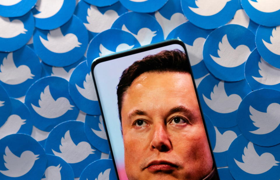 An image of Elon Musk is seen on smartphone placed on printed Twitter logos in this picture illustration taken April 28, 2022. REUTERS/Dado Ruvic/Illustration