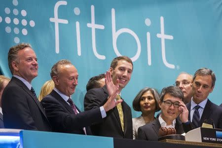 James Park (3rd R), Fitbit CEO, stands behind co-founder and CTO Erid Friedman (C) as he waves before ringing the opening bell on the day of the company's IPO above the floor of the New York Stock Exchange, June 18, 2015. REUTERS/Lucas Jackson