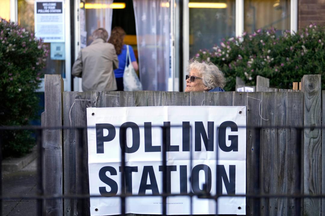 Voters arrive at a polling station in London, Thursday, July 4, 2024. Voters in the U.K. are casting their ballots in a national election to choose the 650 lawmakers who will sit in Parliament for the next five years. Outgoing Prime Minister Rishi Sunak surprised his own party on May 22 when he called the election, which could have taken place as late as January 2025. Polls opened at 7 a.m. and will close at 10 p.m. on Thursday night. (AP Photo/Vadim Ghirda)