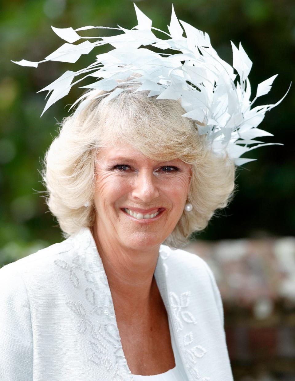 <p> At the wedding of her son, Tom Parker Bowles, Queen Camilla debuted a stunning white, feathered headpiece. The feathers are designed to look like they are in motion, arching over in a wave formation. </p>