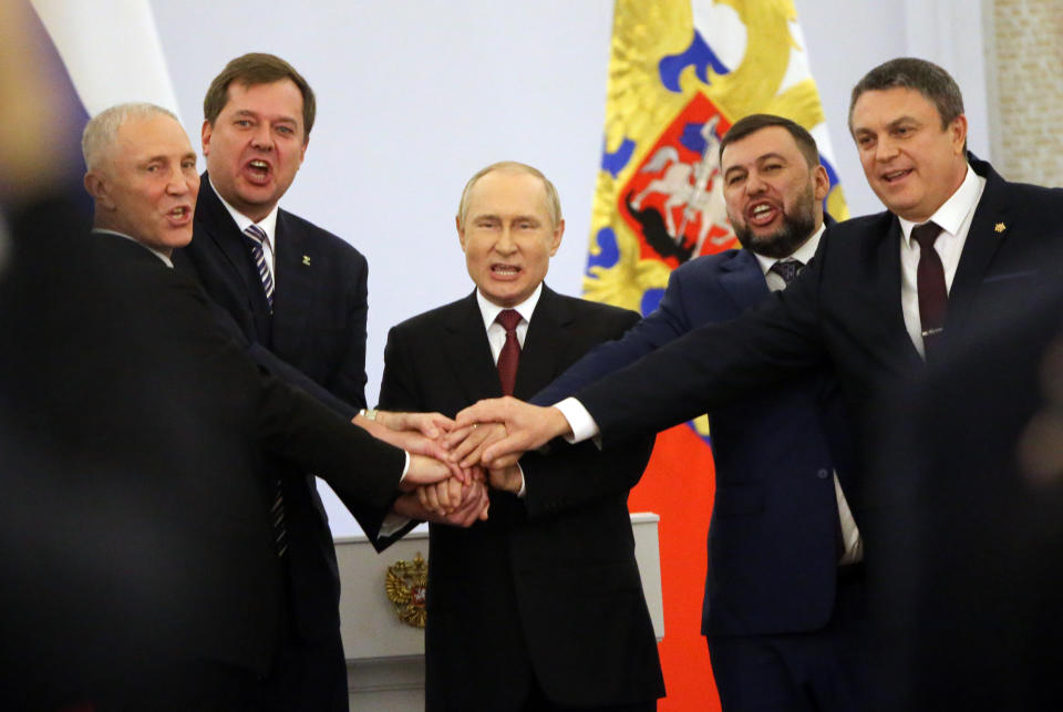 Russian President Vladimir Putin stands with four Ukrainian separatist regional leaders.