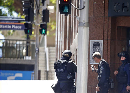 New South Wales state police officers are seen at a corner near Lindt cafe in Martin Place, where hostages are being held, in central Sydney December 15, 2014. REUTERS/Jason Reed