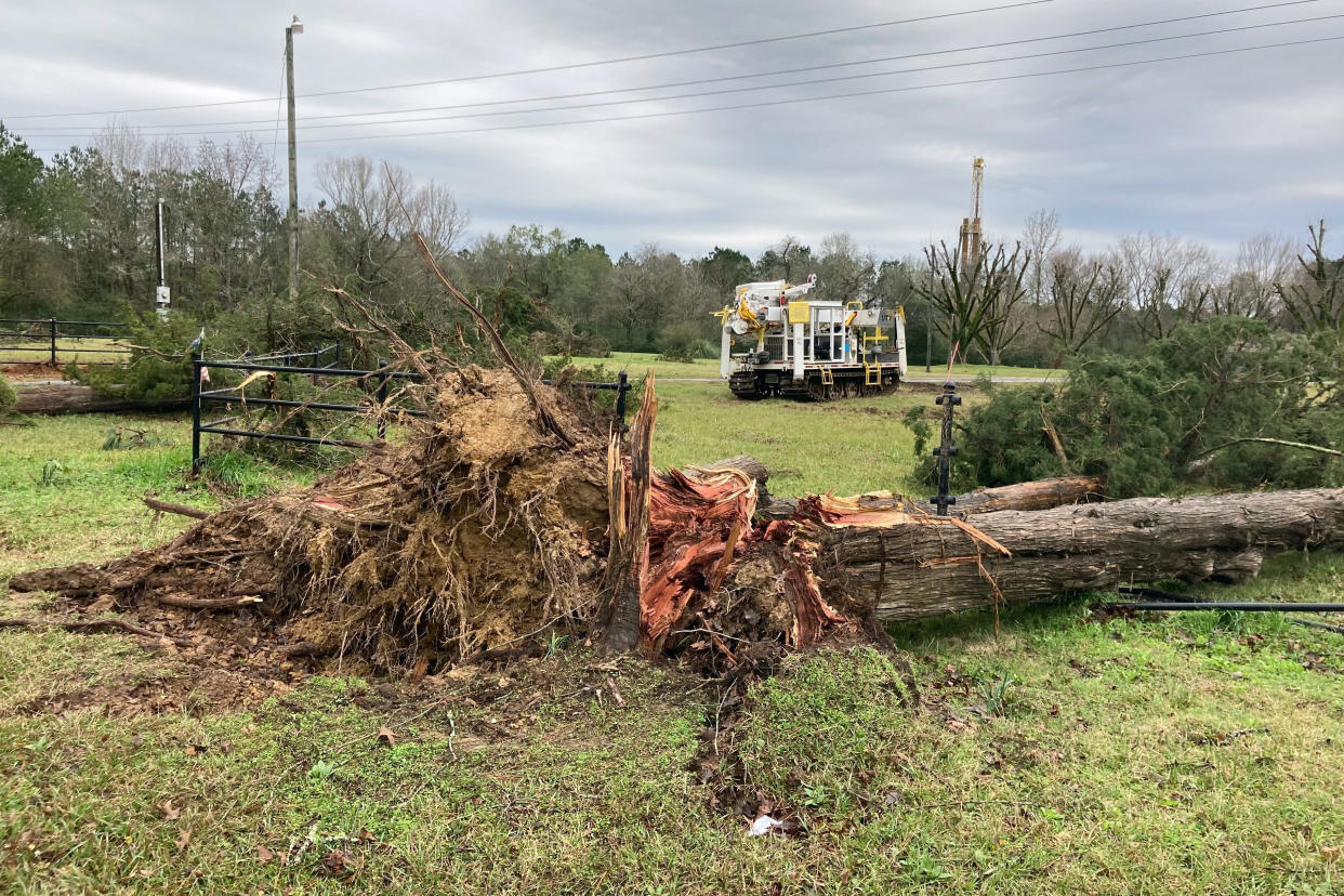 A tree is uprooted following severe weather Wednesday, Dec. 14, 2022, in Keithville, La. A volatile storm ripping across the U.S. spawned tornadoes that killed a young boy and his mother in Louisiana, smashed mobile homes and chicken houses in Mississippi and threatened neighboring Southern states with more punishing weather Wednesday. (AP Photo/Jake Bleiberg)