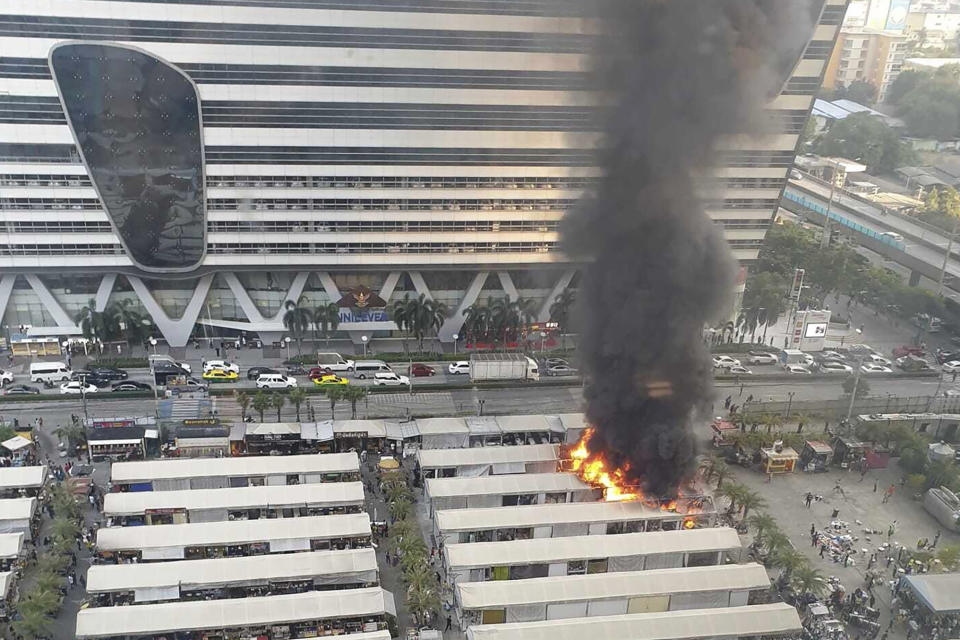 This photo provided by Dusadee Deena Chiewcharnvalichakij shows a fire at a popular open market, as seen from a nearby building in central Bangkok on Wednesday, Dec. 13, 2023, spewing clouds of black smoke visible from all over the Thai capital. It caused minimal damage and only one known injury, a fire official said. (Dusadee Deena Chiewcharnvalichakij via AP)