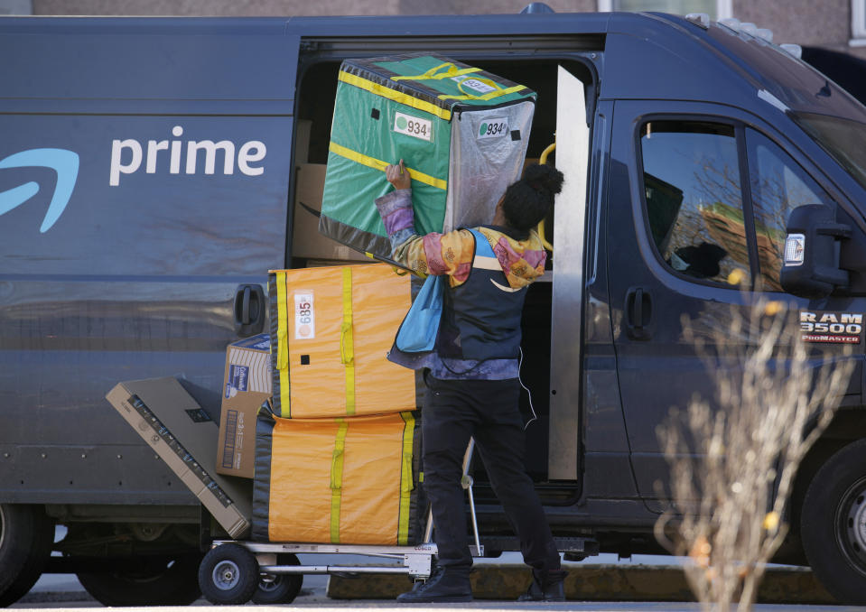 FILE - An Amazon Prime delivery person lifts packages while making a stop at a high-rise apartment building, Nov. 28, 2023, in Denver. Amazon delivered packages to its Prime customers at the fastest speeds ever in 2023, the retailer said Tuesday, Jan. 30, 2024, thanks to better inventory placement, a new regionalization model for shipments and more same-day warehouses. (AP Photo/David Zalubowski, File)