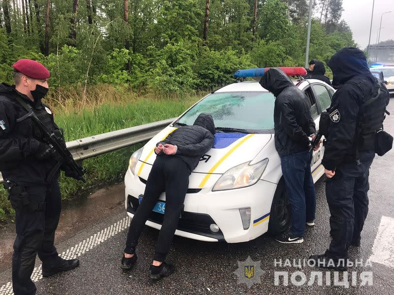 Police officers detain men suspected of taking part in a recent armed conflict in Zhytomyr Region
