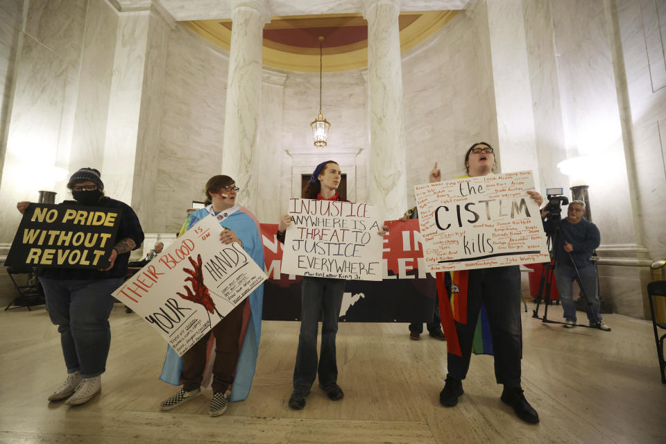 Protestors hold signs during a rally opposing HB2007 at the state capitol in Charleston, W.Va., on March 9, 2023. HB2007 would ban health care for trans children in the state. (AP Photo/Chris Jackson)