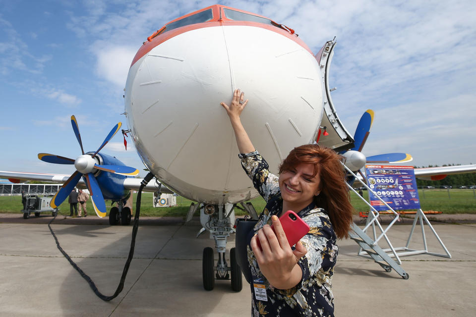 <p>A visitor takes a selfie with an Ilyushin Il-114 twin-engine turboprop airliner on display at the MAKS-2017 International Aviation and Space Salon in Zhukovsky, Moscow Region, Russia, July 18, 2017. (Photo: Sergei Bobylev/TASS via Getty Images) </p>