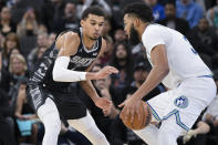 Minnesota Timberwolves' Karl-Anthony Towns, right, drives against San Antonio Spurs' Victor Wembanyama during the second half of an NBA basketball game, Saturday, Jan. 27, 2024, in San Antonio. San Antonio won 113-112. (AP Photo/Darren Abate)