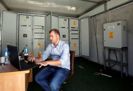 A Palestinian engineer works on a computer at a solar plant in Tubas, in the occupied West Bank July 23, 2018. REUTERS/Mohamad Torokman