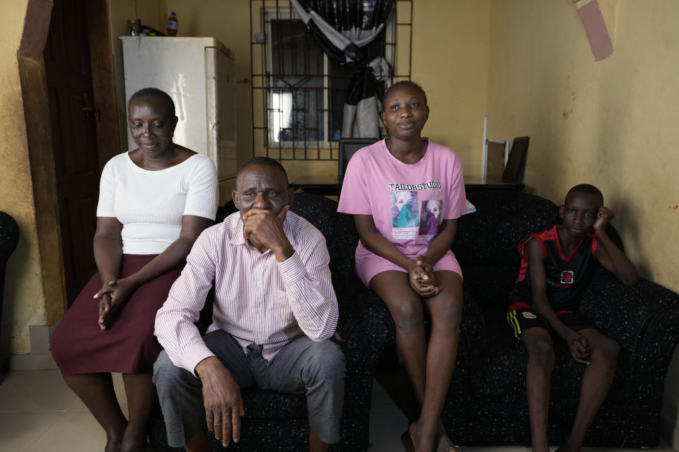 Pius Orofin, a deck operator aboard the Trinity Spirit oil ship, sits with his family during an interview at their home in Okitipupa, Nigeria, on Tuesday, Sept. 6, 2022. The Trinity Spirit’s surviving crew members have been plagued by ailments long after their escape from the fire. Orofin’s hearing is damaged, and he has a long scar on his leg. Not long after that vivid night, still in the throes of recovery, he and colleague Patrick Aganyebi were taken to jail for 19 days. (AP Photo/Sunday Alamba)