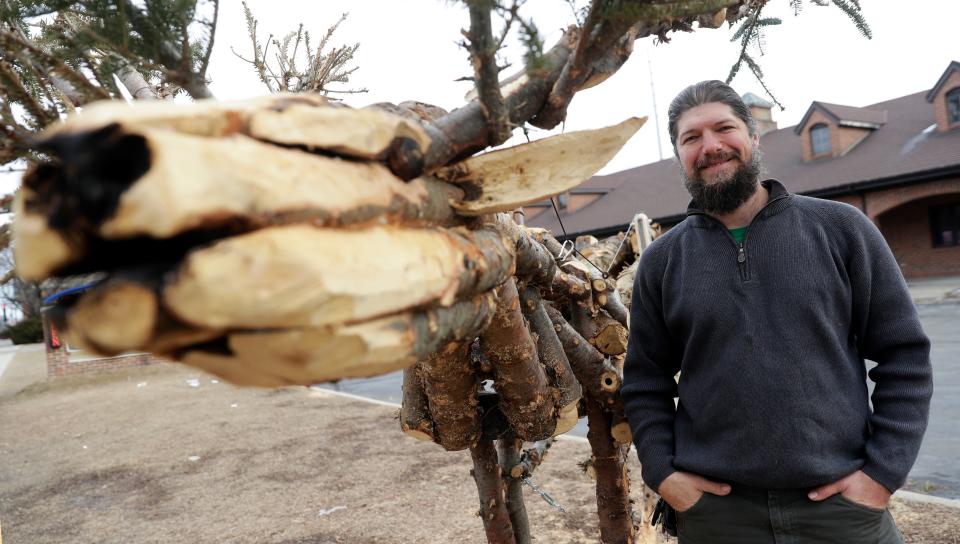 Artist Casey Early-Krueger used the trunks and branches of old Christmas trees to create a stag sculpture on display in Green Bay's Broadway District.