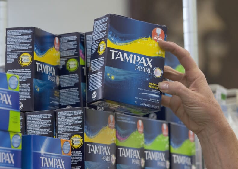 FILE - In this June 22, 2016, file photo, Tammy Compton restocks tampons at Compton's Market, in Sacramento, Calif. California public schools and colleges would have to stock their restrooms with free menstrual products under legislation sent to Gov. Gavin Newsom on Thursday, Sept. 9, 2021. The bill by Democratic Assemblywoman Cristina Garcia builds on her 2017 law requiring low-income schools in disadvantaged areas to provide students with free menstrual products. (AP Photo/Rich Pedroncelli, File)