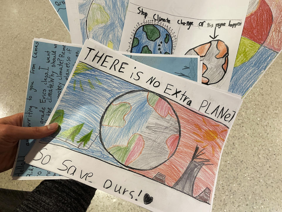 Sarah Stapleton, a University of Oregon education professor, holds drawings and letters from elementary school students asking lawmakers to stop climate change, after testifying at a hearing at the Oregon State Capitol in Salem, Ore., Thursday, March 9, 2023, in favor of a bill that would require climate change instruction in public schools from kindergarten through 12th grade. (AP Photo/Claire Rush)