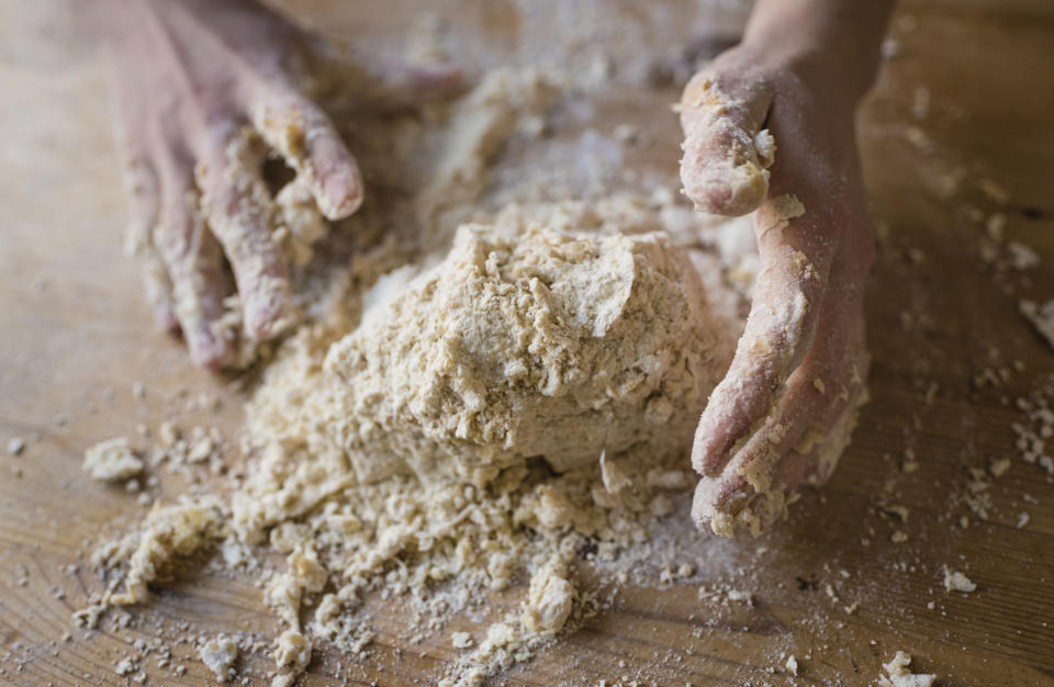 Hands kneading bread dough.