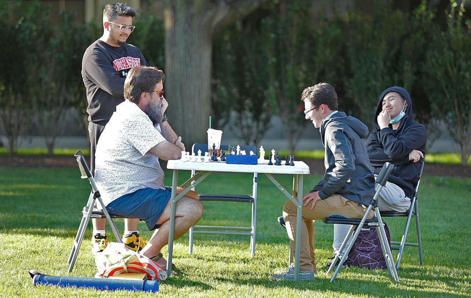Chess players Michael Yezukevich and Andrew Doucette play a match on the Hancock Adams Common in Quincy with Raj Phadke and Yang Hongchen watching the moves. Yezukevich, an instructor, is trying to find a location to host a chess club. Monday, Sept. 4, 2023.