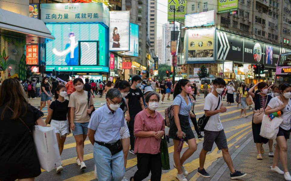 Pedestrians cross a road in the Causeway Bay area in Hong Kong, China - Billy H.C. Kwok /Bloomberg