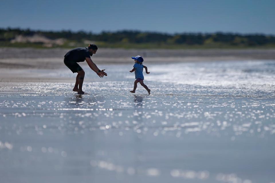 Evie Torres, 2, runs toward her father Gabe Torres as the pair enjoy a beach day together at Horseneck Beach in Westport, to celebrate Mr. Torres' birthday.