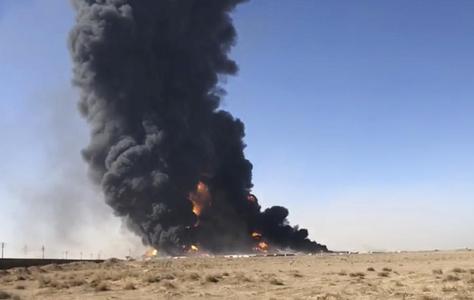 FILE- In this Saturday, Feb. 13, 2021 still image taken from video, smoke rises from fuel tankers at the Islam Qala border with Iran, in Herat Province, west of Kabul, Afghanistan. Taliban have taken control of Islam Qala crossing border in western Herat province at the neighboring Iran, an Afghan official and Iranian media confirmed on Thursday, July 8. (AP Photo, File)