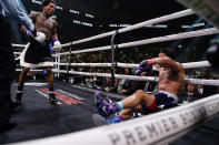 The referee restrains Gervonta Davis, left, after he knocked down Rolando Romero during the sixth round of a WBA lightweight championship boxing bout early Sunday, May 29, 2022, in New York. Davis won in the sixth round. (AP Photo/Frank Franklin II)