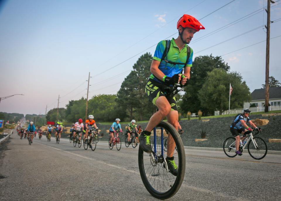 Kyle Campbell of Dubuque (@unikyle on Twitter) rides his unicycle as riders roll out of Sac City on RAGBRAI in 2021.