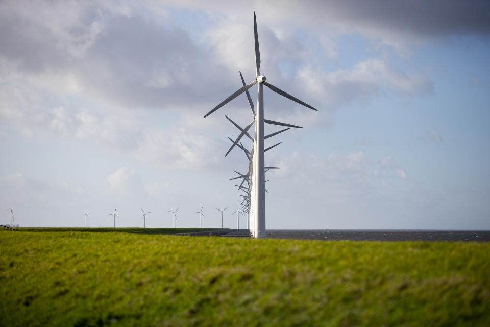 Wind turbines are seen on a dike near Urk, Netherlands, Friday, Jan. 22, 2021. A group of scientists, including five Nobel laureates, called Friday for more action to adapt the world to the effects of climate change, drawing comparisons with the faltering response to the coronavirus crisis, ahead of a major online conference on climate adaptation starting Monday and hosted by the Netherlands. (AP Photo/Peter Dejong)