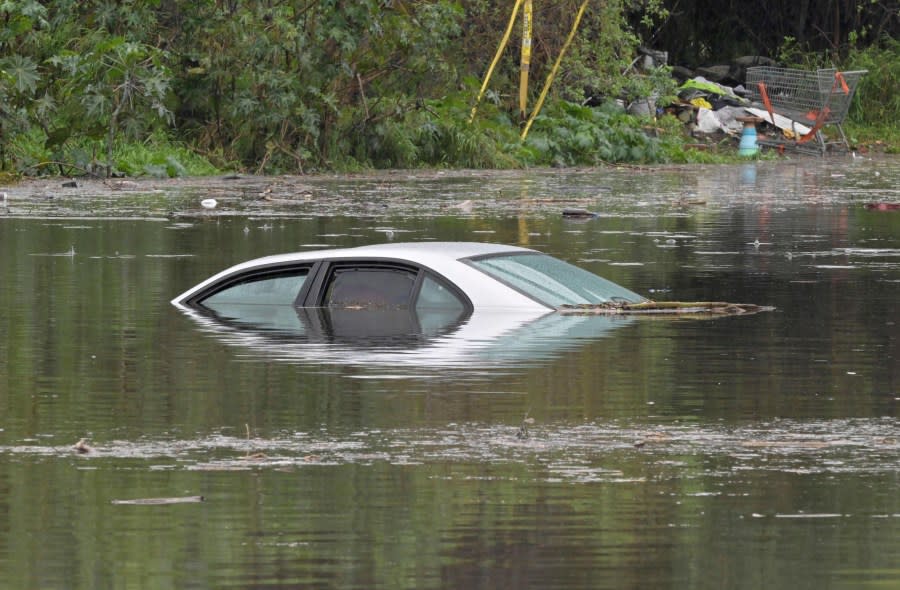 A car is nearly completely submerged under flood waters in Long Beach, Calif., Thursday, Feb. 1, 2024. Heavy rain flooded roadways and much-needed snow piled up in the mountains on Thursday as the first of back-to-back atmospheric rivers pummeled California. (Brittany Murray/The Orange County Register via AP)