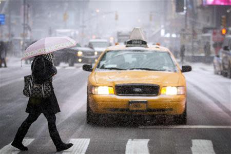 A woman crosses a street in Times Square, New York January 21, 2014. REUTERS/Brendan McDermid