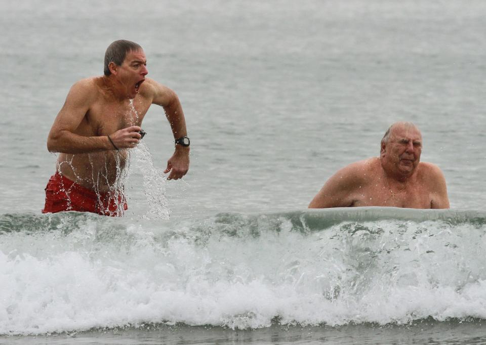 Journal columnist Mark Patinkin, left, and Charlie Wright, a retired member of the Newport Polar Bear Club, come out of the water after taking the plunge at Easton's Beach in December 2014.