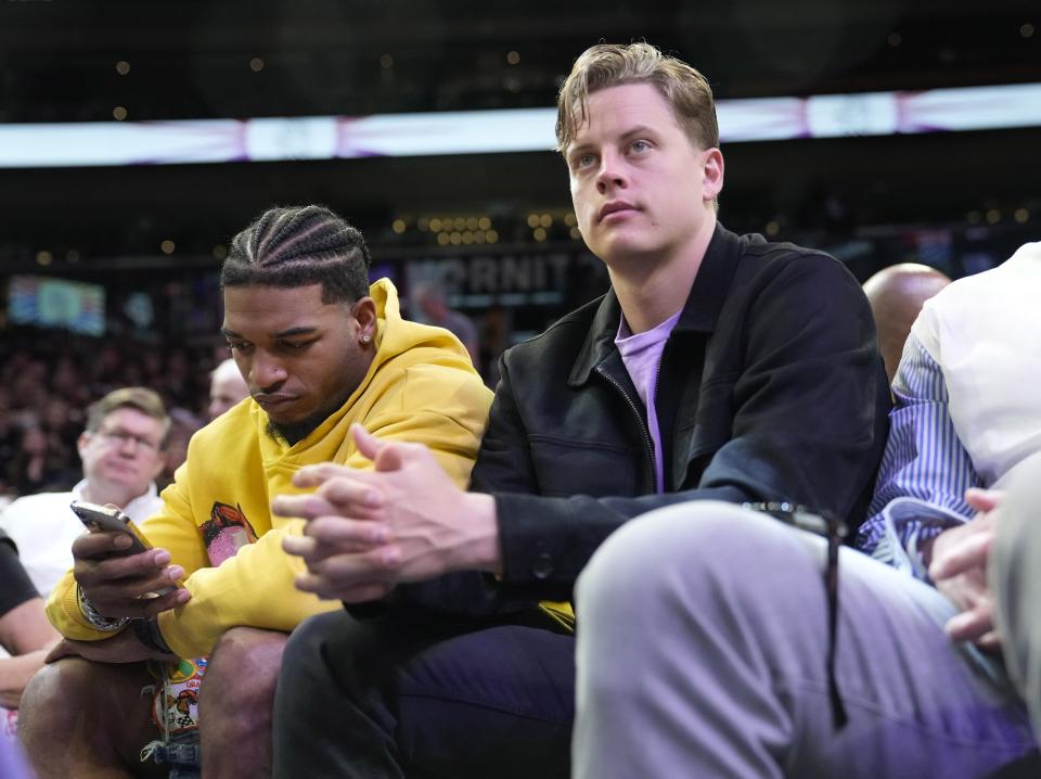 Cincinnati Bengals wide receiver Ja'Marr Chase (left) and quarterback Joe Burrow watch the Phoenix Suns and the Los Angeles Lakers play during the first quarter at Footprint Center in Phoenix on Feb. 25, 2024.