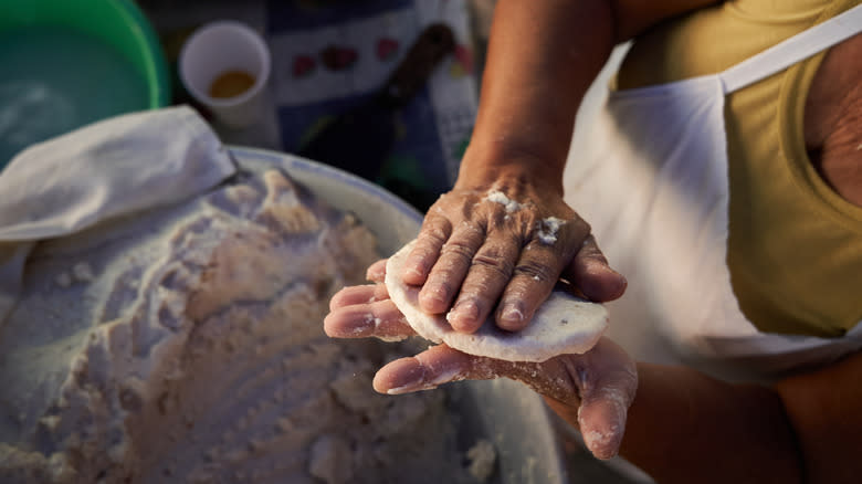 person making tortillas by hand