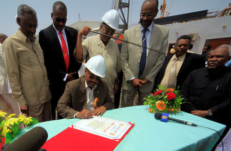 FILE PHOTO: Sudanese President Omar Hassan al-Bashir signs documents to launch the White Nile Sugar Co sugar plant during its opening in Al-Diwaim July 11, 2012. REUTERS/Mohamed Nureldin Abdallah/File Photo